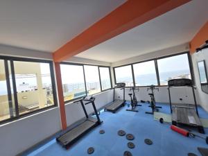 a gym with two treadmills in a room with windows at Elegance appart-Yoff virage in Dakar