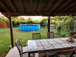 a table and chairs under a pergola in a yard at Къща за гости Азария in Resilovo