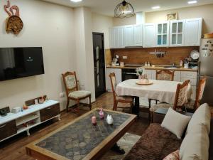 a living room with a table and a kitchen at Къща за гости Азария in Resilovo