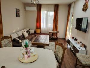 a living room with a table and a couch at Къща за гости Азария in Resilovo