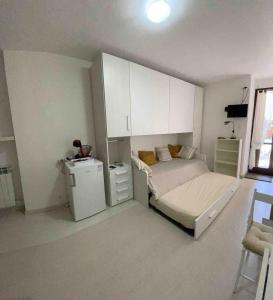 a bedroom with a bed and a small refrigerator at Studio apartment on the lake in Lovere