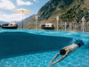a man swimming in a swimming pool in the water at Gourmet & Wine Hotel Austria - 4 Sterne superior - Hike & Bike in Obergurgl +80 photos