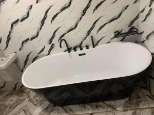 a white toilet in a black and white bathroom at Seychelles Bella House in Mahe +3 photos