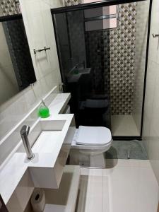 a white bathroom with a toilet and a sink at Estrela de Euclides in Euclides da Cunha