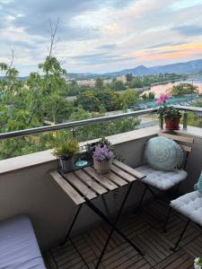 a balcony with a wooden table and potted plants at River view Kardzhali in Kŭrdzhali