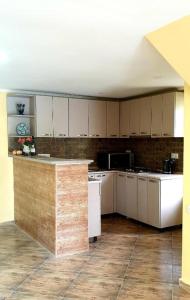 a large kitchen with white cabinets and a counter at Four seasons in Kutaisi