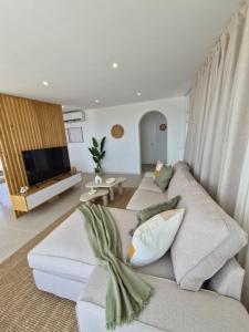 a living room with a white couch and a tv at Gándara Lodge Luxury in Tijoco de Abajo