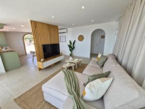 a living room with a white couch and a tv at Gándara Lodge Luxury in Tijoco de Abajo