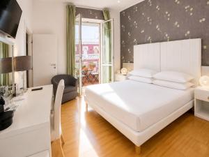 a bedroom with a large white bed and a desk at B&B Pellicano Guest House in Reggio di Calabria