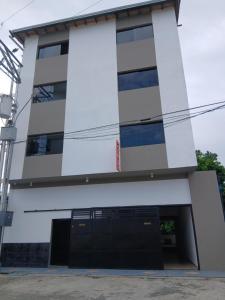 ein weißes Gebäude mit schwarzen Türen und Fenstern in der Unterkunft Hotel Terranova in El Vigía
