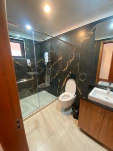 a bathroom with a shower and a toilet and a sink at Progressive Park Hotel in Nairobi
