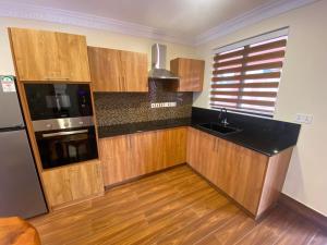 a kitchen with wooden cabinets and a black counter top at Progressive Park Hotel in Nairobi