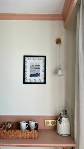 a shelf with bowls and a picture on the wall at Hotel Saint-Enogat in Dinard