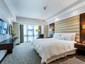 a hotel room with a large bed and a desk at Swissotel Lima in Lima