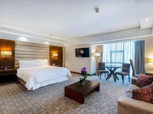 a hotel room with a bed and a living room at Swissotel Lima in Lima