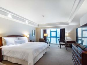 a hotel room with a large bed and a desk at Swissotel Lima in Lima