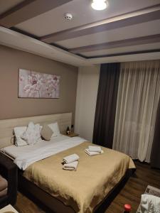 a bedroom with a large bed with towels on it at Milmari Kopaonik in Kopaonik +5 photos