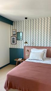 a bedroom with a large bed with a red blanket at Hotel Saint-Enogat in Dinard