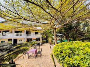 a garden with a table and chairs and a building at Nature Kigali in Kigali