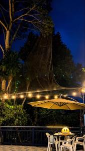 a table and chairs with an umbrella at night at Cazabela in Casisang