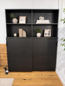 a black book shelf with potted plants and books at Altstadt-Loft Würzburg in Würzburg +1 photo