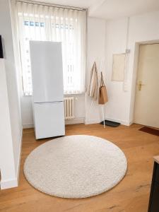 a white room with a white refrigerator and a rug at Altstadt-Loft Würzburg in Würzburg