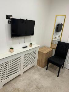 a living room with a television and a chair at Holiday Plus - 50 Palatine Road in Blackpool
