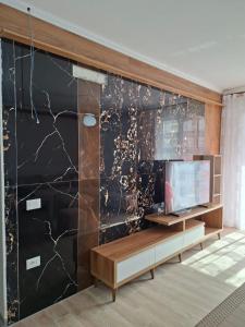 a living room with a black marble wall at Rafaelo Apartament in Lezhë