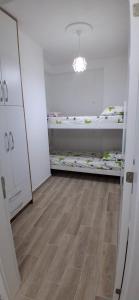 a room with two bunk beds and a wooden floor at Rafaelo Apartament in Lezhë +3 photos
