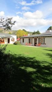 a house with a large yard with a large lawn at My Pod House in Esquel