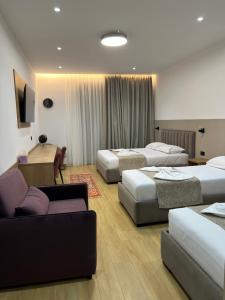 a hotel room with three beds and a desk at Skanderbeg Hotel in Krujë