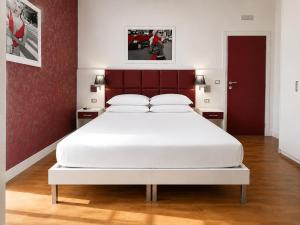 a bedroom with a large white bed with a red headboard at B&B Pellicano Guest House in Reggio di Calabria