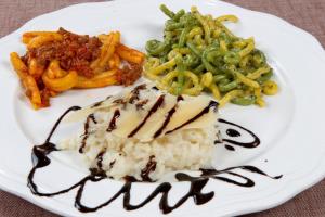 a white plate of food with rice and vegetables at Hotel del Rio Srl - RISTORANTE e Azienda agricola in Casinalbo