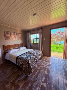 a bedroom with a bed and a large window at Pousada refúgio do lago in Lages +46 photos