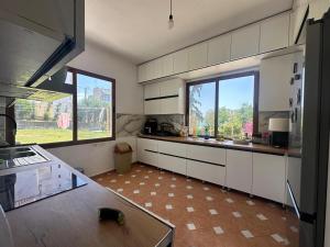 a kitchen with white cabinets and a large window at Villa Sofia in Durrës
