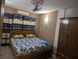 a bedroom with a bed with a blue and white comforter at Hotel Palais D'OR in Ouagadougou