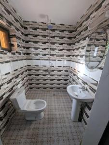a bathroom with a toilet and a sink at Hotel Palais D'OR in Ouagadougou