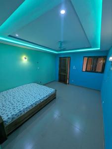 a bedroom with a bed in a blue room at Hotel Palais D'OR in Ouagadougou