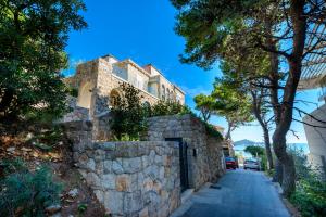 una casa de piedra en una calle con una pared de piedra en Holiday Home Villa Rosemary, en Dubrovnik