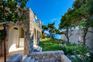 una casa de piedra con una puerta y escaleras hasta un patio en Holiday Home Villa Rosemary, en Dubrovnik