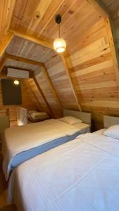 two beds in a room with wooden ceilings at Elegant Residence in Çamlıhemşin