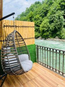 a swing on a porch with a view of the water at Elegant Residence in Çamlıhemşin