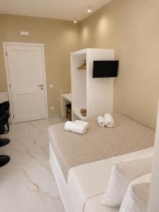 a hotel room with two beds and a tv at Pelekouda Coastal Apartments in Pollonia