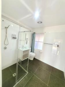 a bathroom with a shower and a toilet and a sink at Christian's Minde Jervis bay in Jervis Bay Village +59 photos