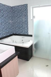 a bathroom with a bath tub and a shower at Barra Parque Hotel in Jaraguá do Sul