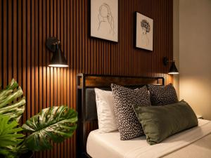 a bedroom with a bed with pillows and paintings on the wall at Boxstel - Modern Stay Hotel Downtown El Paso in El Paso