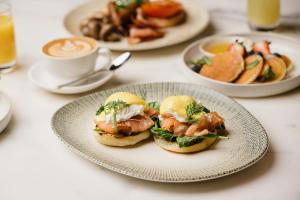 a plate with two sandwiches and a cup of coffee at InterContinental Brisbane by IHG in Brisbane
