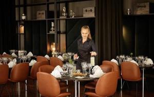 a woman standing at a table in a restaurant at Comwell in Odense