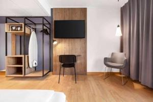 a room with two chairs and a flat screen tv at Comwell in Odense