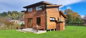 a small wooden house with a bench in a yard at Cabañas Llifén Costanera in llifen